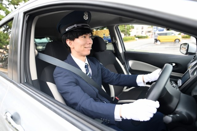 タクシーの運転席でハンドルを握る運転手（イメージ）